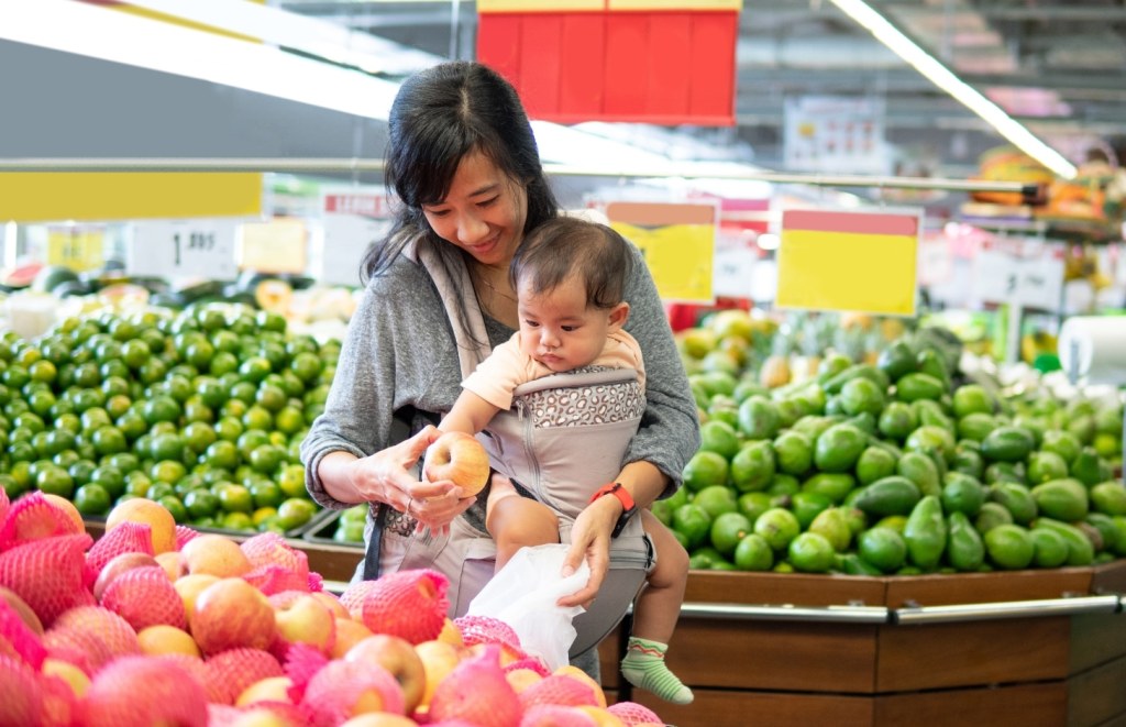 mother and baby picking vegetables at the grocery
