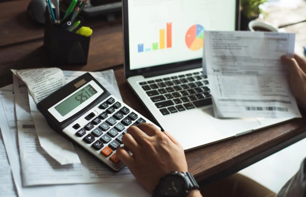 person with bills and calculator