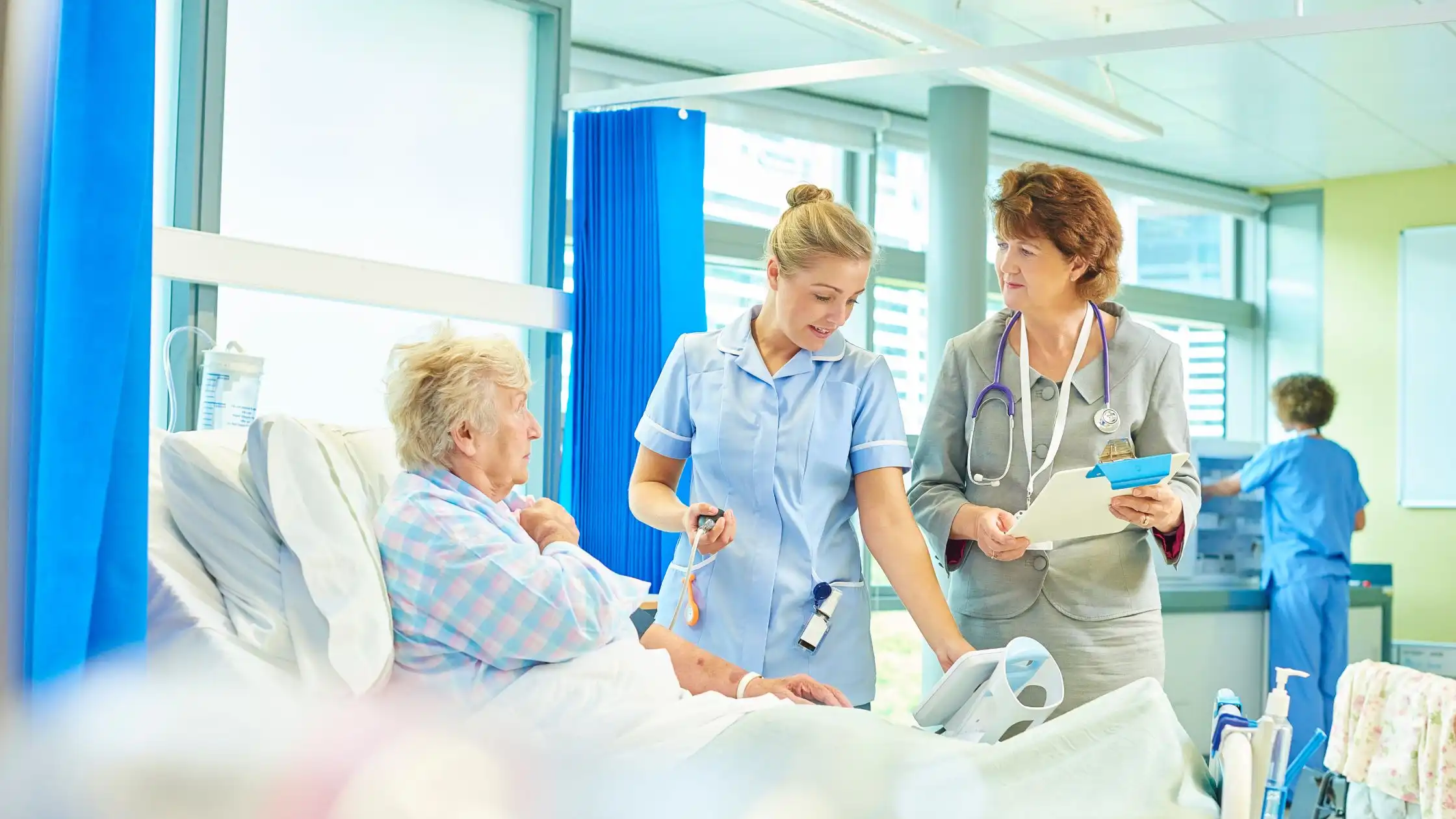 nurse examining senior patient on hospital bed