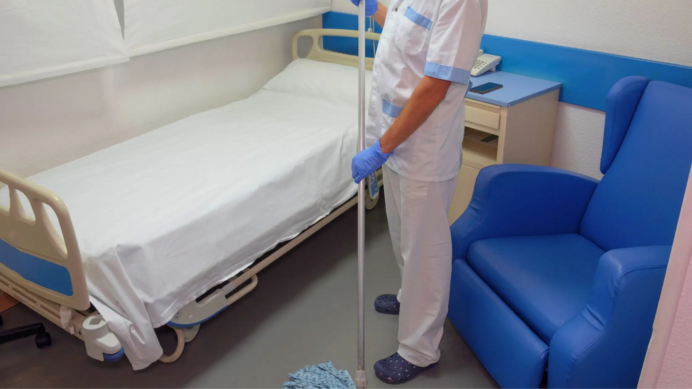 medical janitorial staff mopping patient room